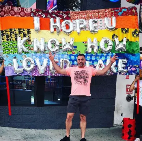 Mike Bayer posing in front of a pride flag