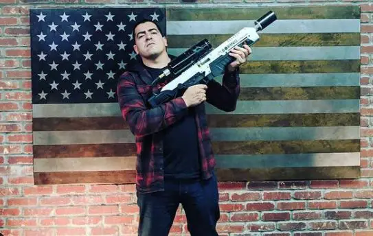 Ed Calderon posing with a gun in his hands