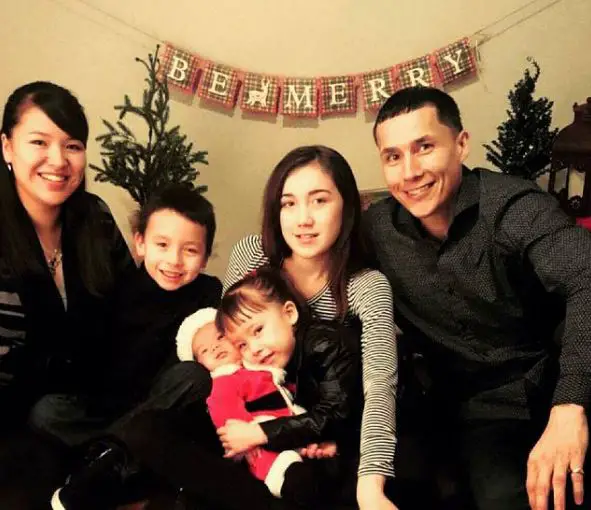 Ricko DeWilde with his partner, Rona Mary, and his children posing for a holiday picture