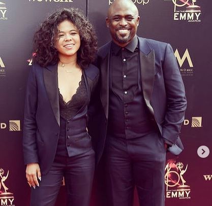 Wayne Brady posing with his daughter, Maile, on a red carpet event