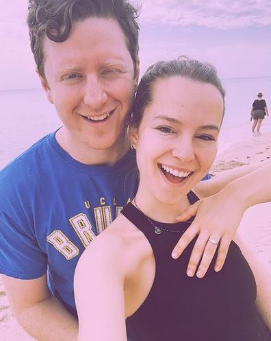 Bridgit flaunting her engagement ring in the picture with Griffing standing right behind her 