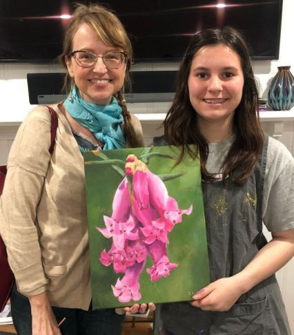 Ila holding her self-created flower painting 